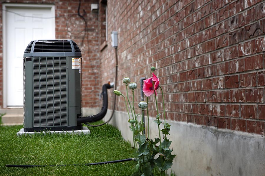 Residential AC maintenance unit beside brick home in Westchester County